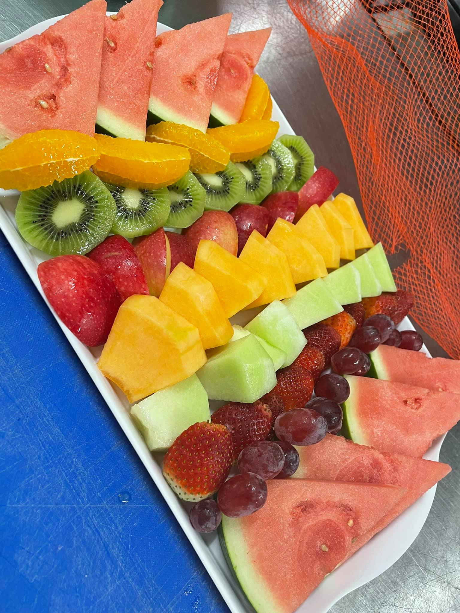 A vibrant fresh fruit platter with sliced melon, berries, and grapes.